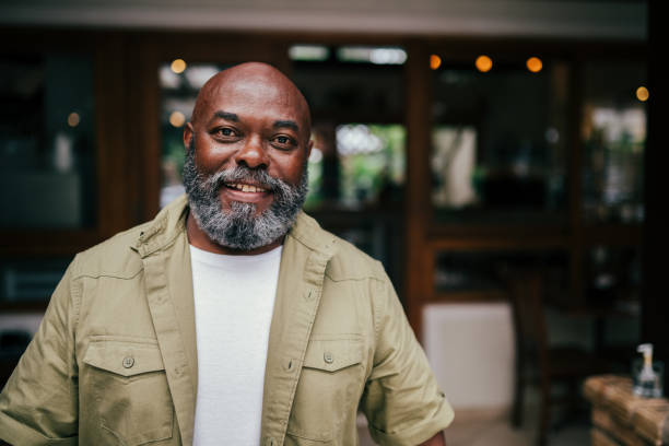 Portrait of a smiling black man, standing looking at camera and smiling